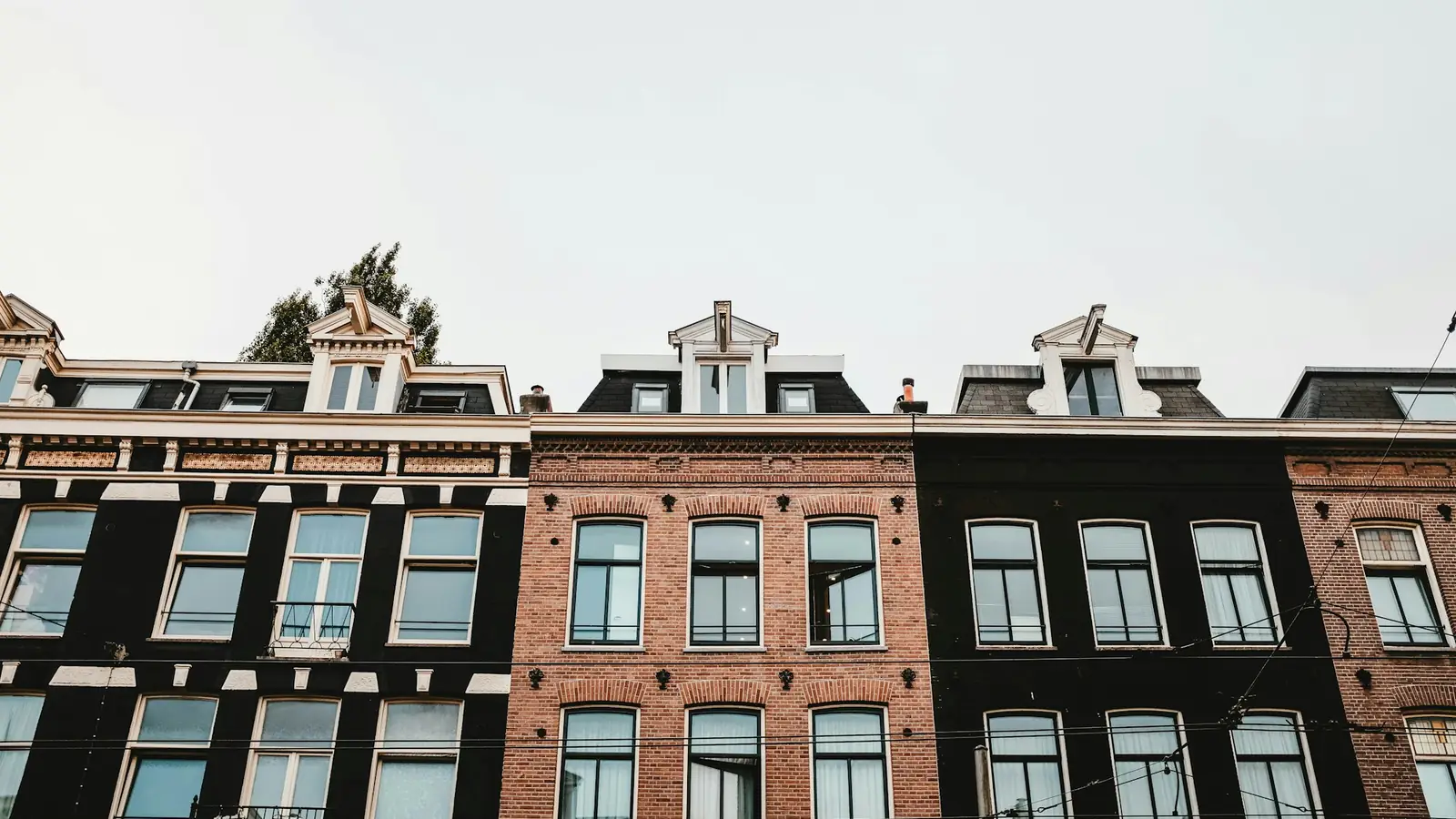 Bakstenen gevels van een rij stadse appartementenpanden met veel ramen